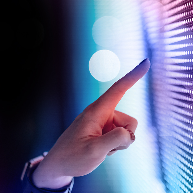Close up of an index finger pointing at a screen with colored data points