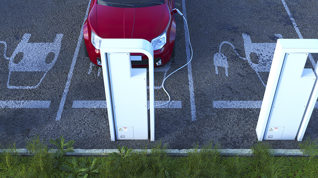 Aerial view of a red electric vehicle parked at a charging station