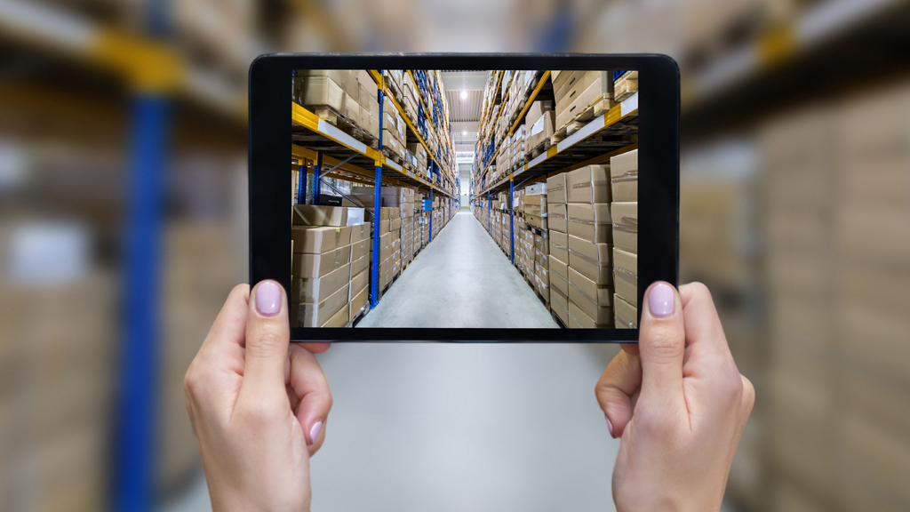 Hands holding an iPad in a retail warehouse